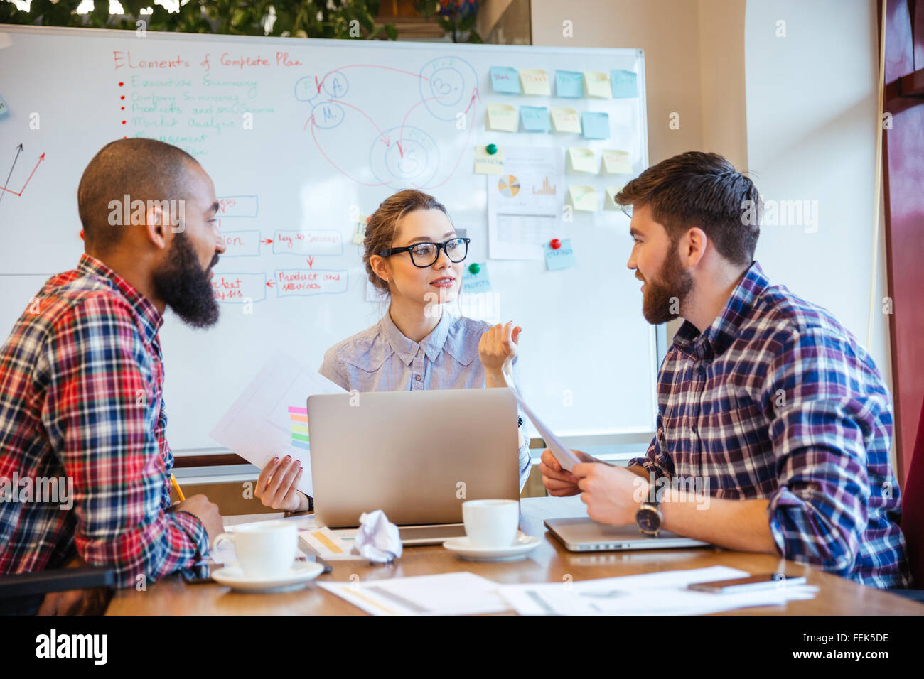 Grupo de jóvenes que trabajan en serio reunión de negocios juntos Foto de stock