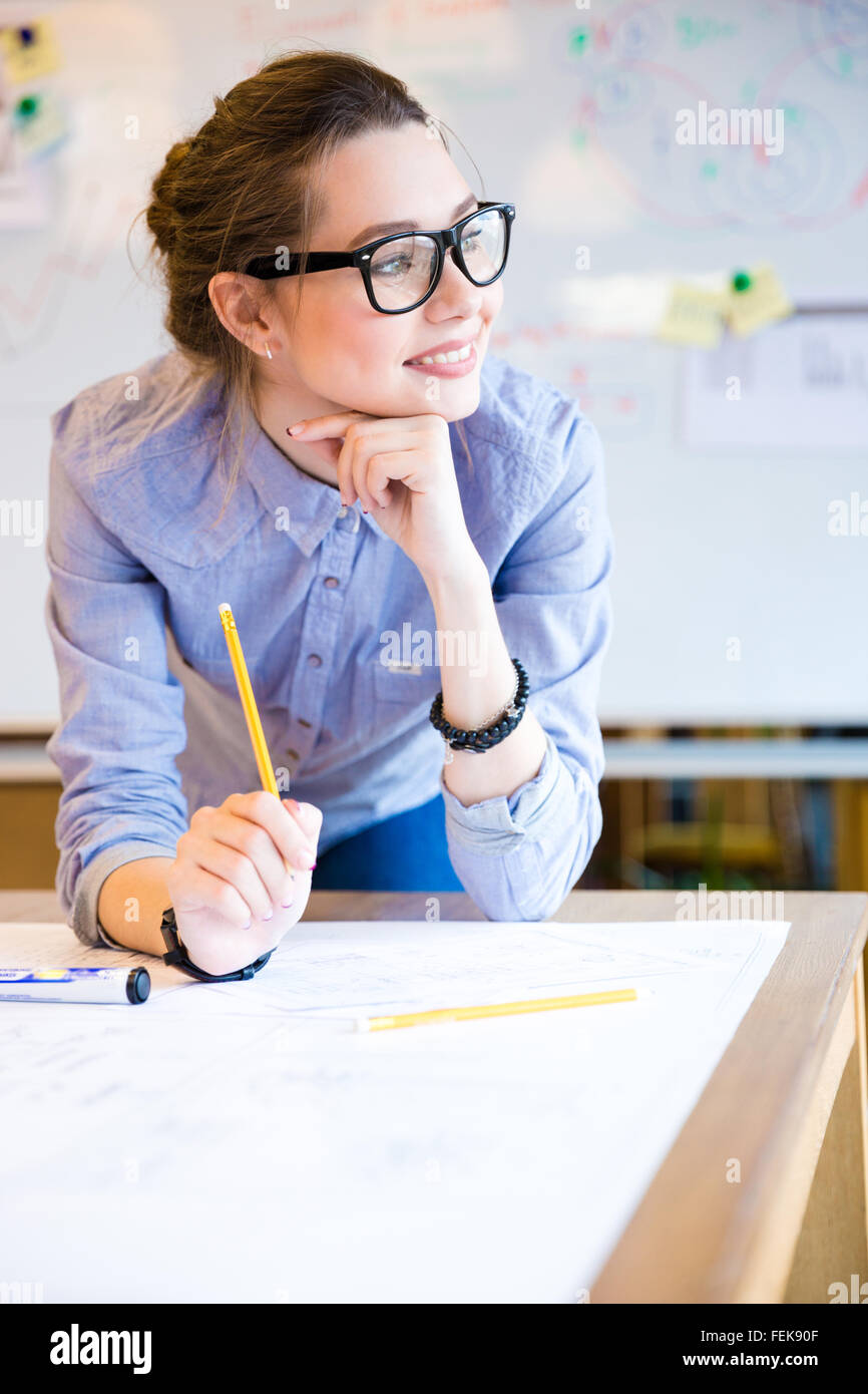 Inspirado joven y bella mujer de negocios en vidrios trabajando en Office Foto de stock