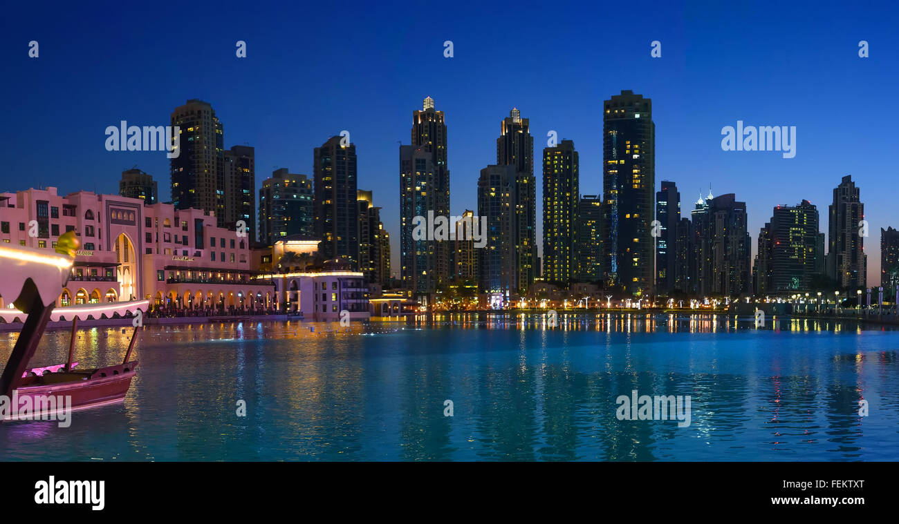 Cerca del lago Burj Khalifa en Dubai por la noche con rascacielos en el fondo Foto de stock