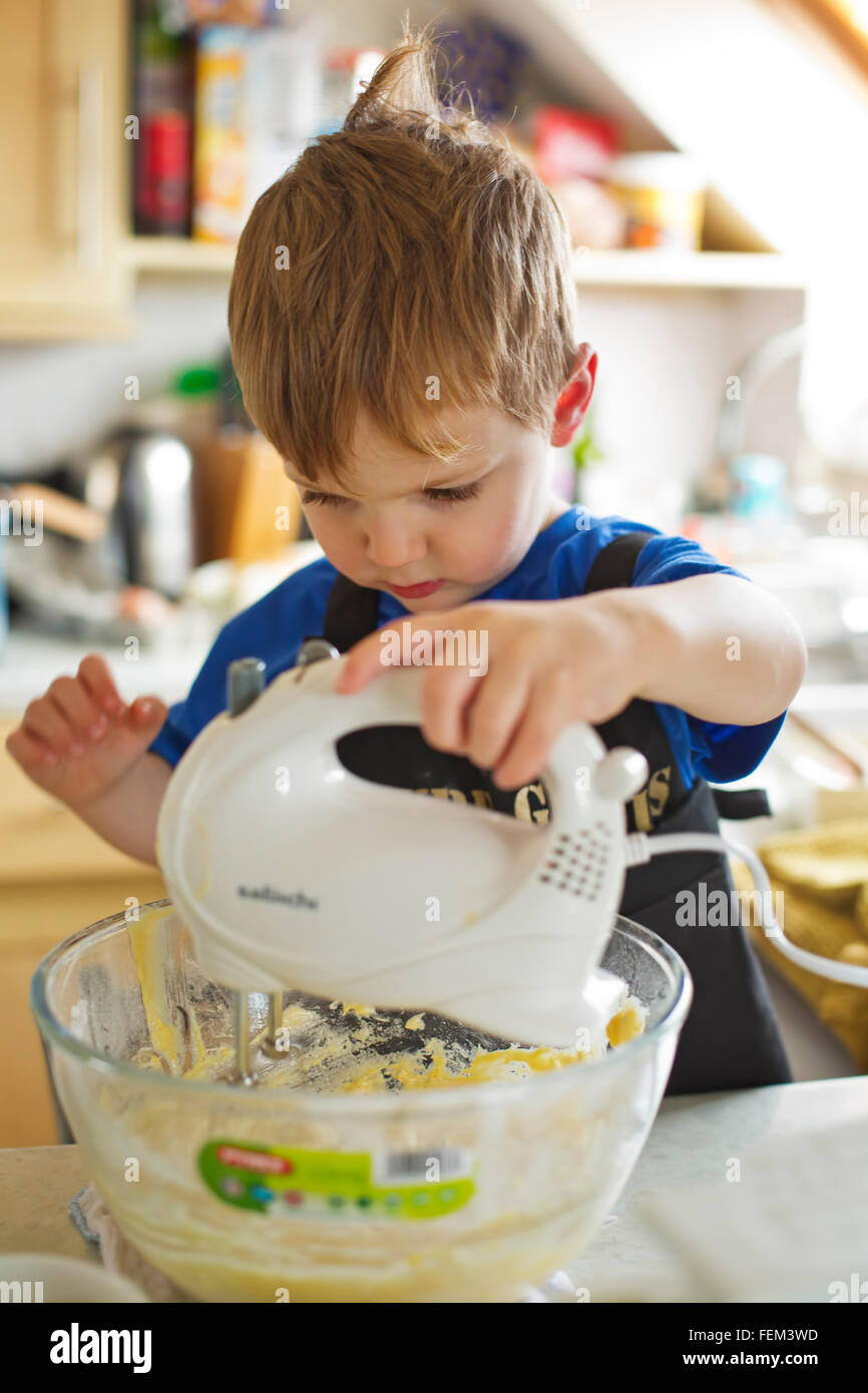 Un niño pequeño aprende a cocinar Foto de stock