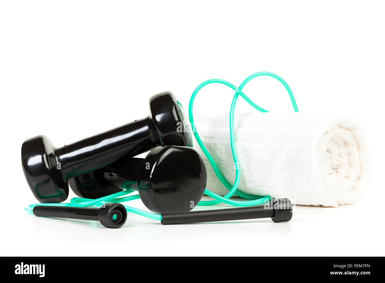 Ejercicio corporal - equipo de pesas, cuerda y una toalla sobre fondo blanco. Foto de stock