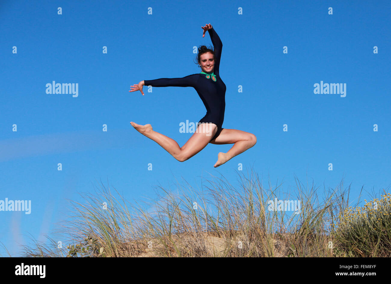 Una gimnasta está haciendo su rutina en la playa en el sur de África. Foto de stock