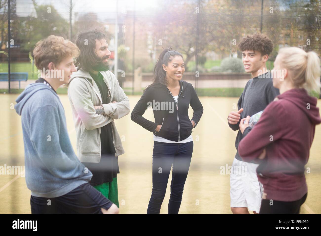 Grupo de adultos de pie en el polideportivo urbano, hablando Foto de stock