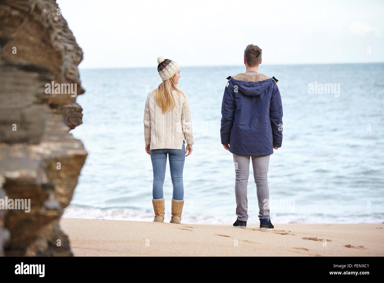 Vista trasera de la pareja joven en busca de playa, Constantino Bay, Cornwall, Reino Unido Foto de stock