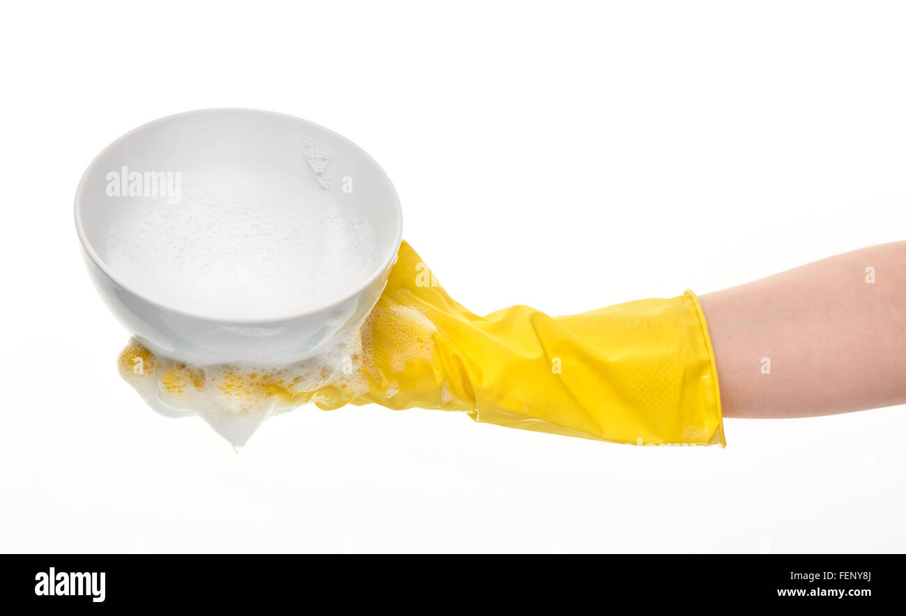 Cerca de mano femenina en amarillo guante de goma protectora mantiene limpio el tazón en espuma blanca contra el fondo blanco. Foto de stock