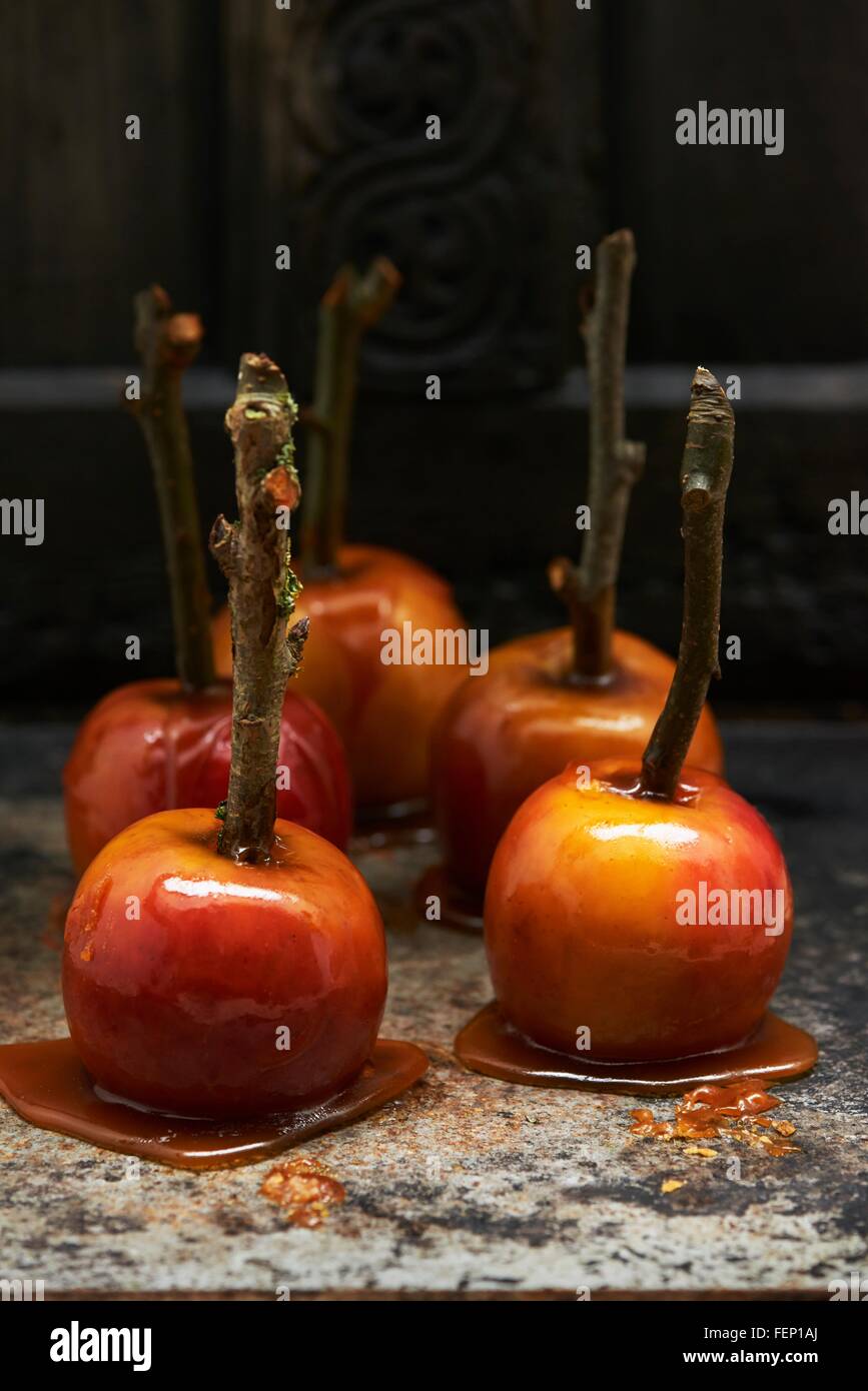 Las manzanas de caramelo sobre palos endurecimiento en superficie de mármol Foto de stock