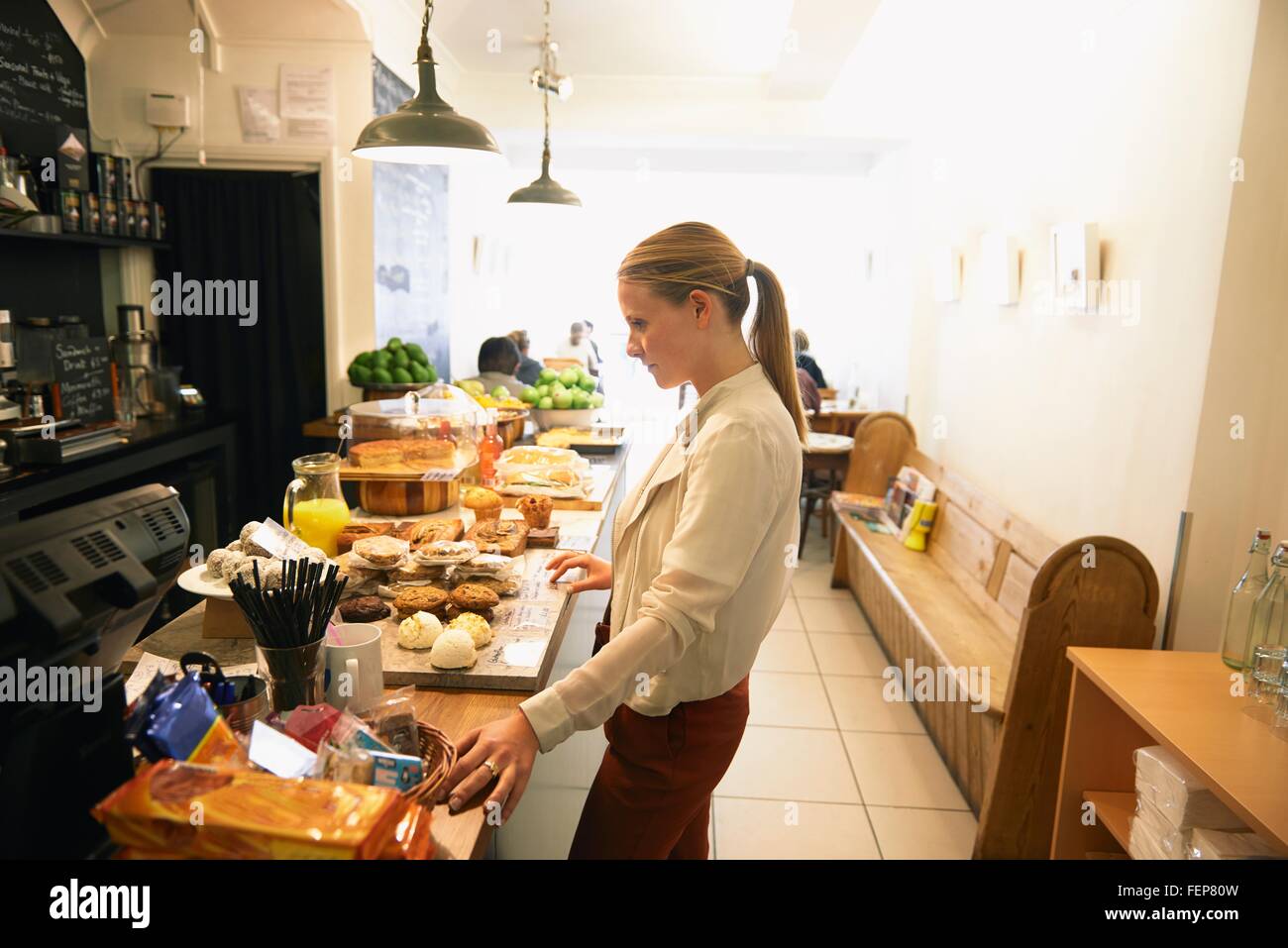 Clienta elegir tortas en cafe counter Foto de stock