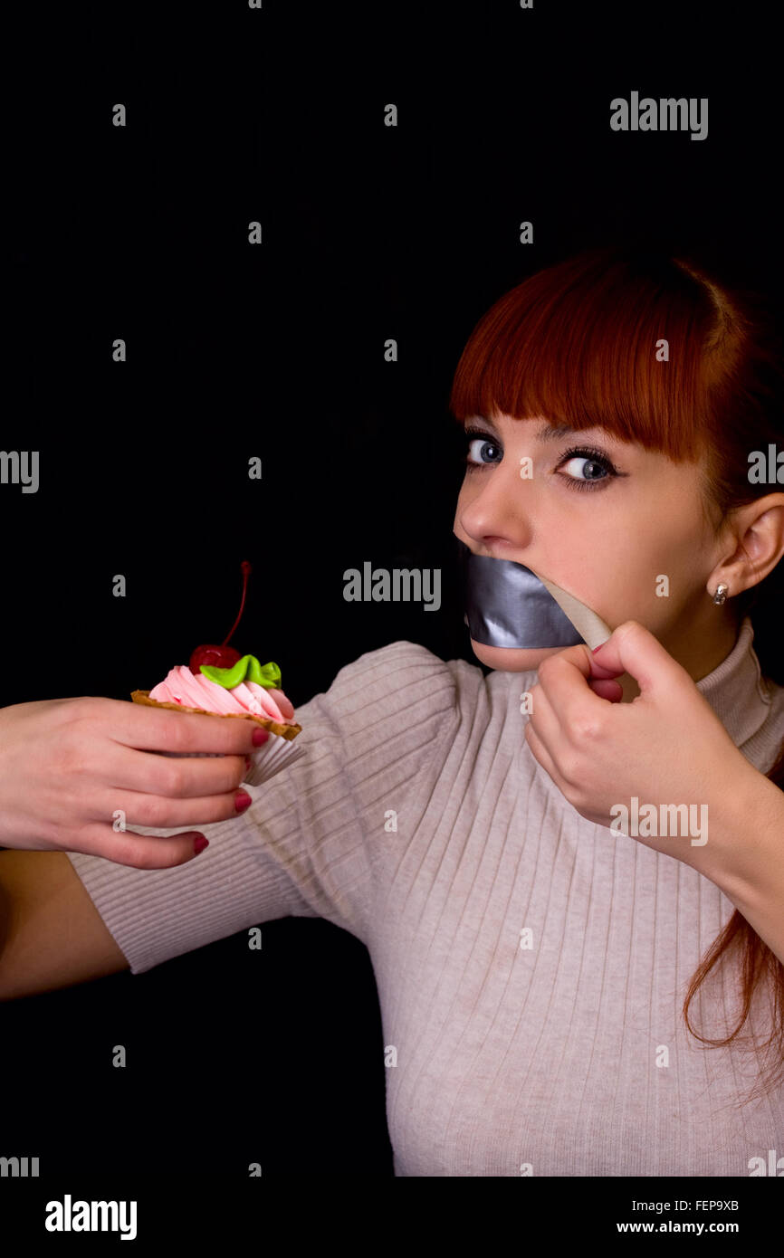 Chica con hambre no podía soportar la dieta y se despega una cinta adhesiva, que ella había grabado su boca Foto de stock