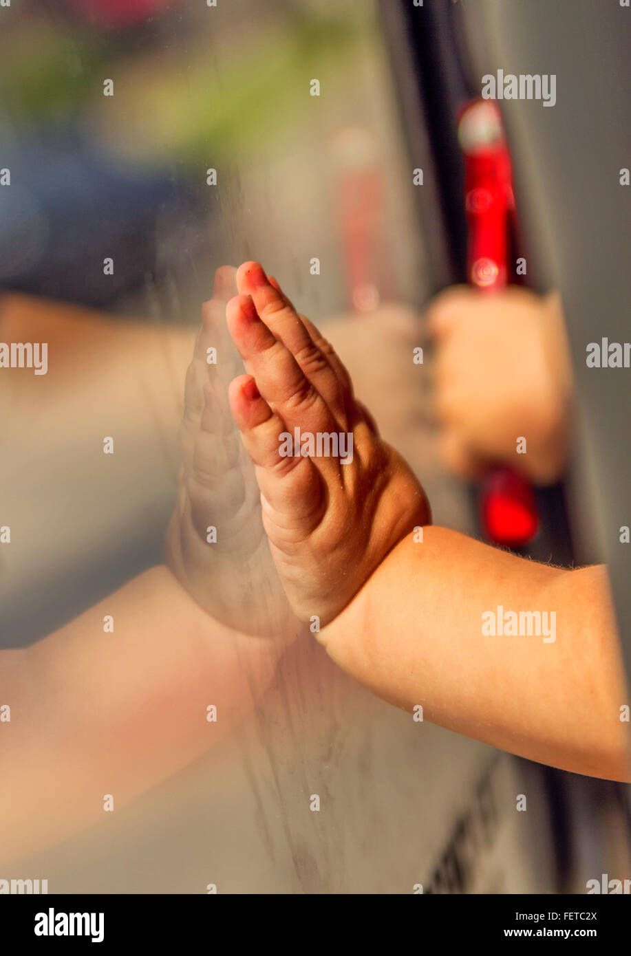 Reflejo de la mano: la reflexión de la mano de un niño tocando el espejo Foto de stock