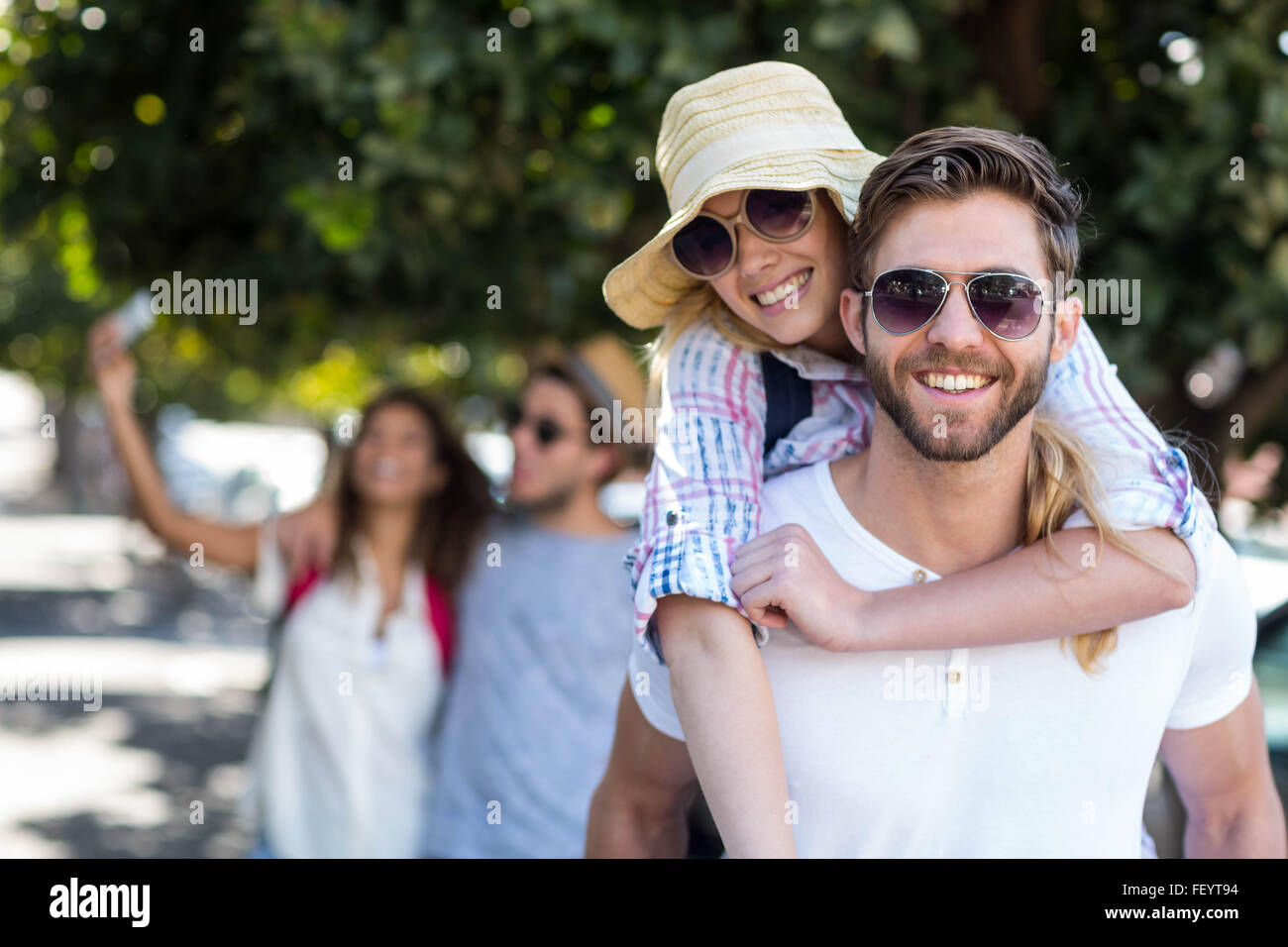 Hombre de cadera dando piggy back a su novia Foto de stock