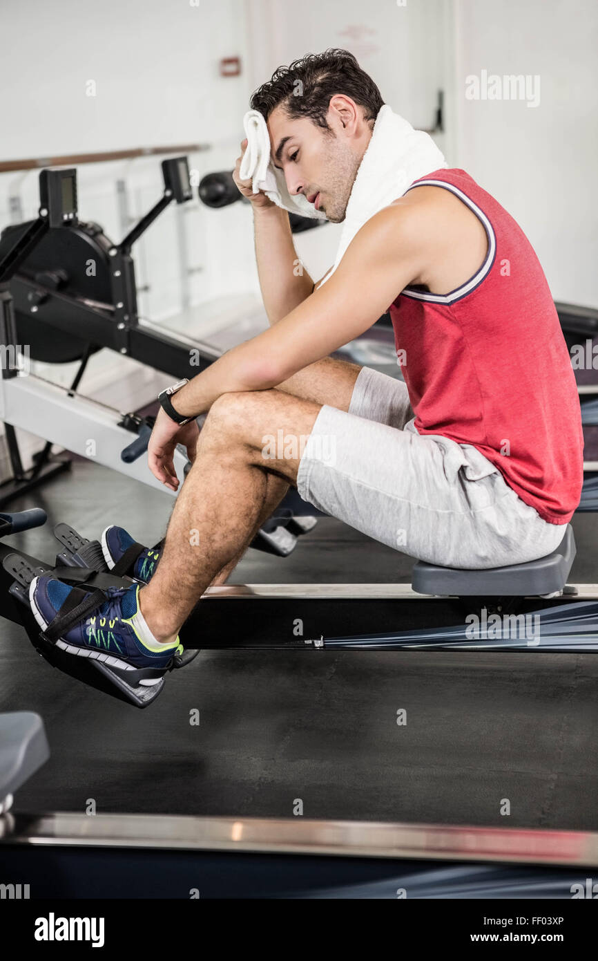 Hombre musculoso posando en el gimnasio con una toalla sobre los hombros.  concepto de fitness.