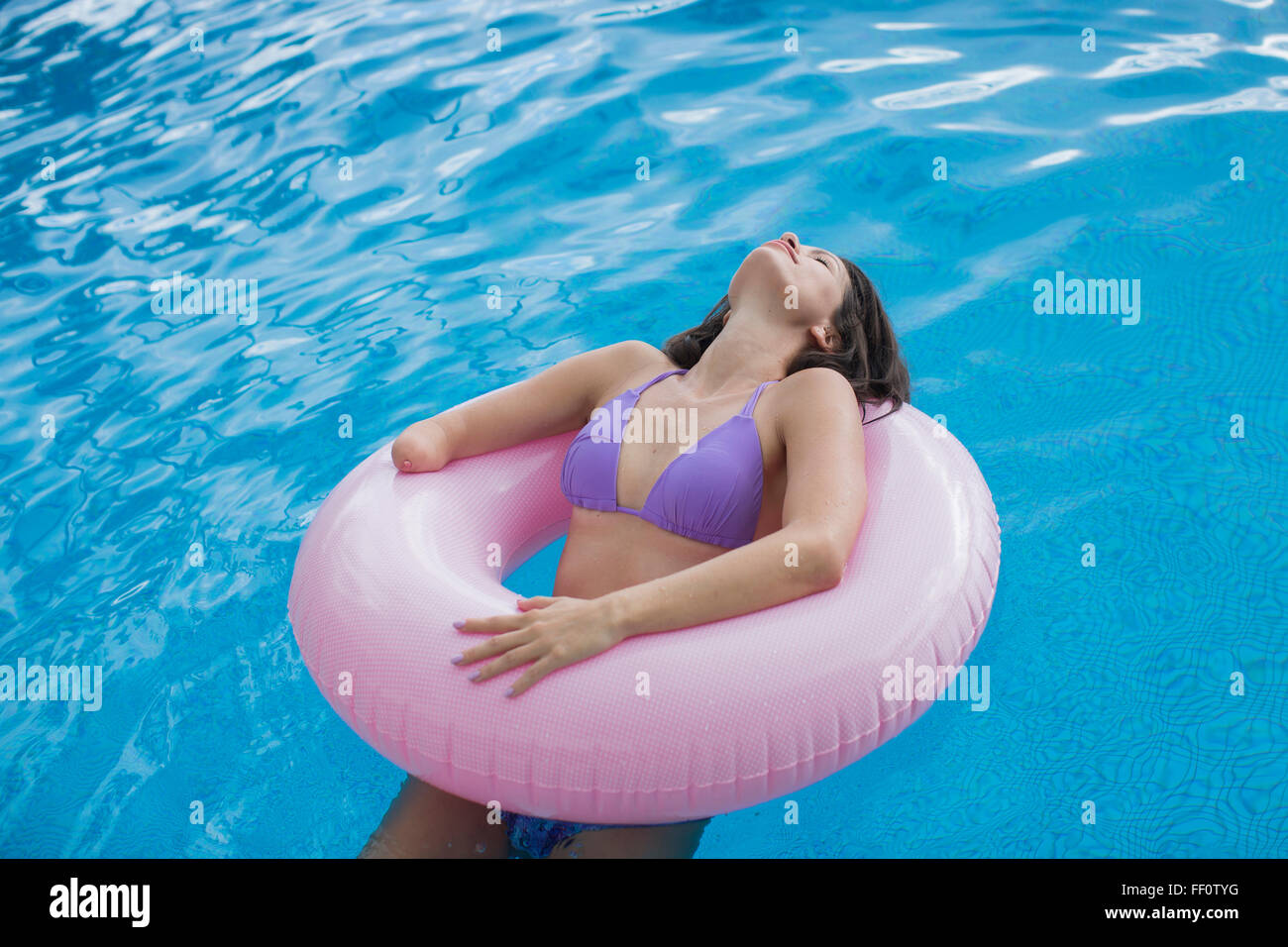 Mujer de raza mixta amputados nadar en piscina Foto de stock