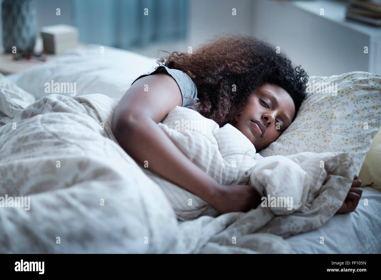 Mujer Negra durmiendo en cama Foto de stock