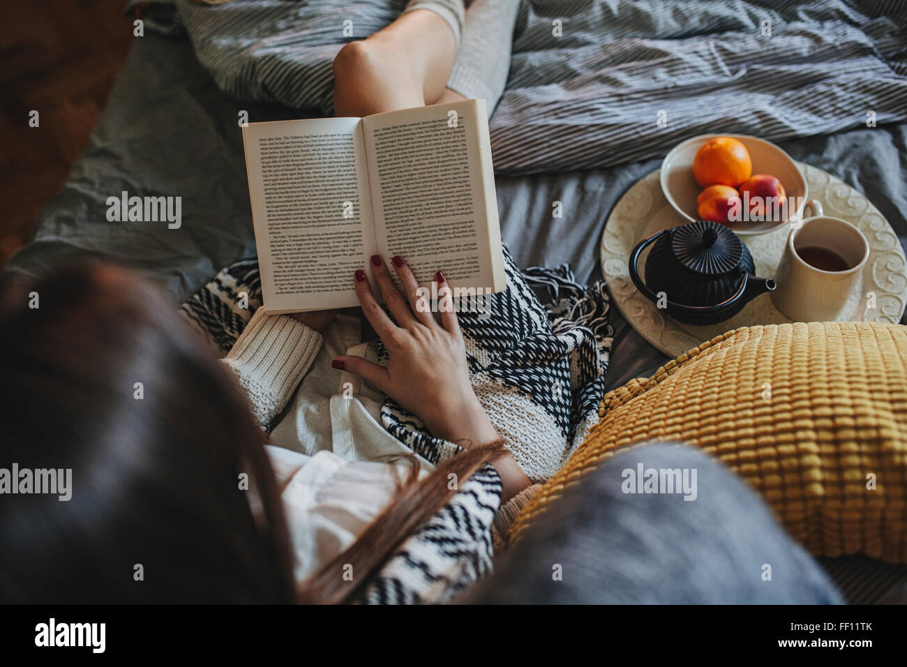 Mujer leyendo el libro sobre la cama Fotografía de stock - Alamy