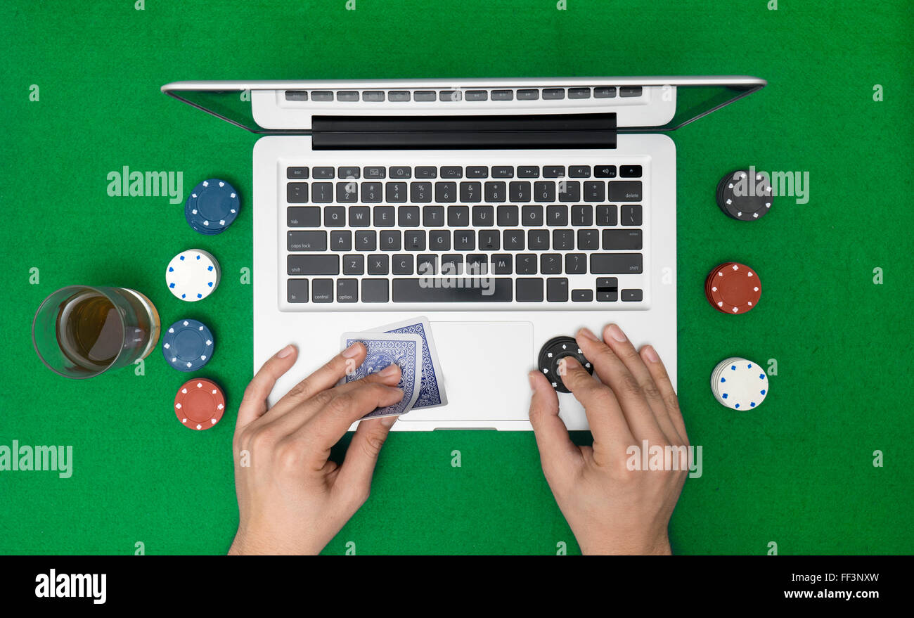 Hombre jugando poker online con laptop sobre una mesa verde con patatas  fritas, vista superior Fotografía de stock - Alamy