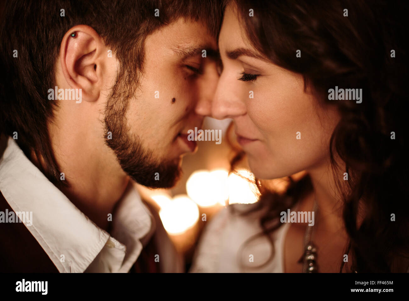 Hermosa pareja con los ojos cerrados disfrutando de los besos y Embrassing uno al otro. Cerrar Headshot, el enfoque selectivo. Foto de stock