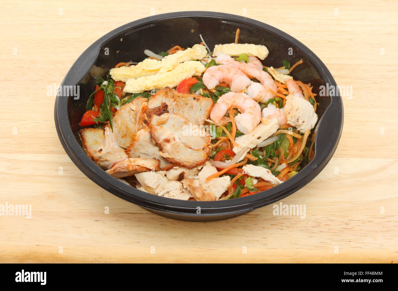 Horno de comida China, Singapur fideos en una caja de plástico sobre una tabla de madera Foto de stock