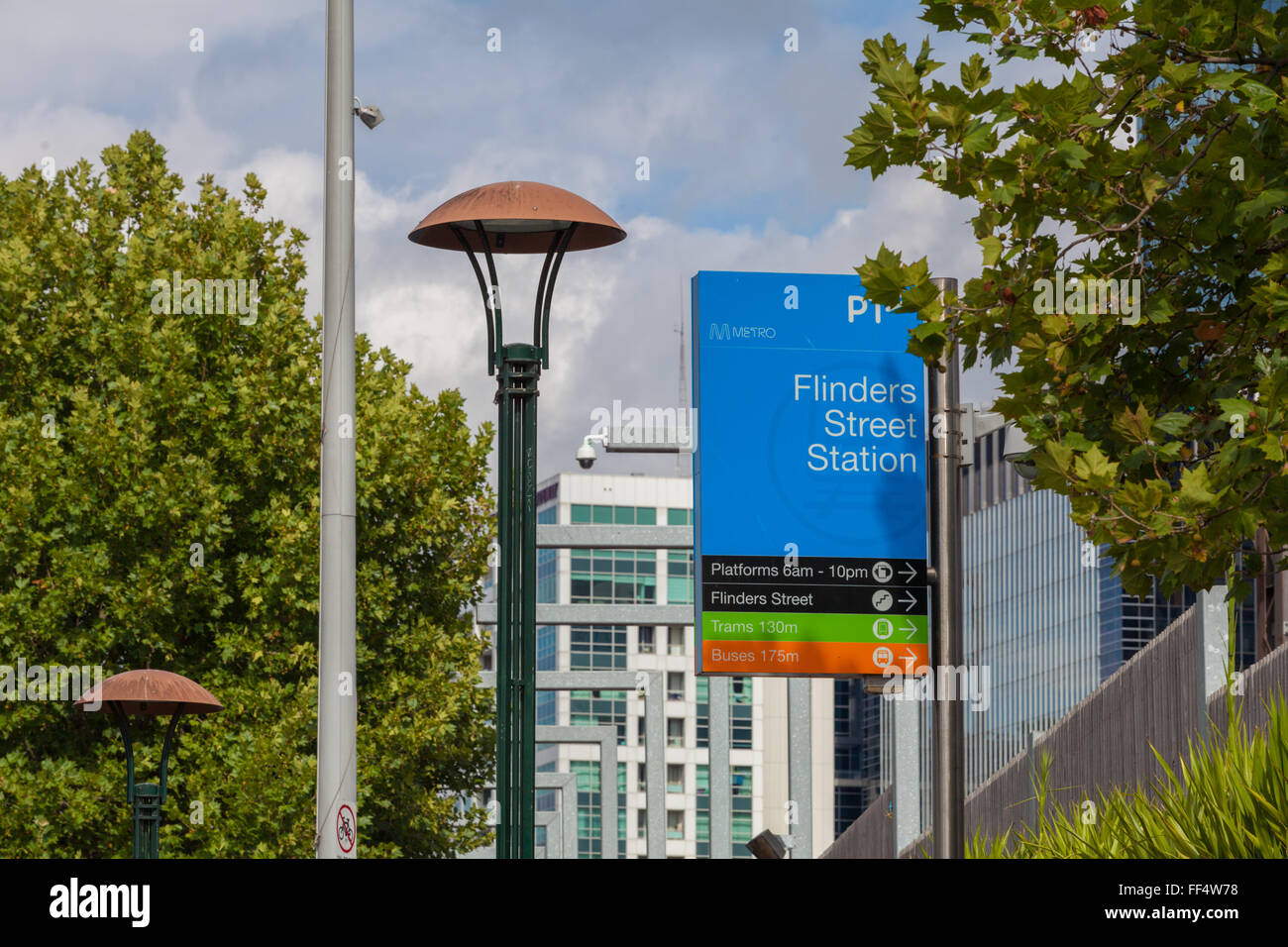 MELBOURNE, Jan 31 2016: La estación de tren de Flinders Street firmar mostrando el camino a las plataformas, tranvías y autobuses. Edificios de oficinas en el BAC Foto de stock