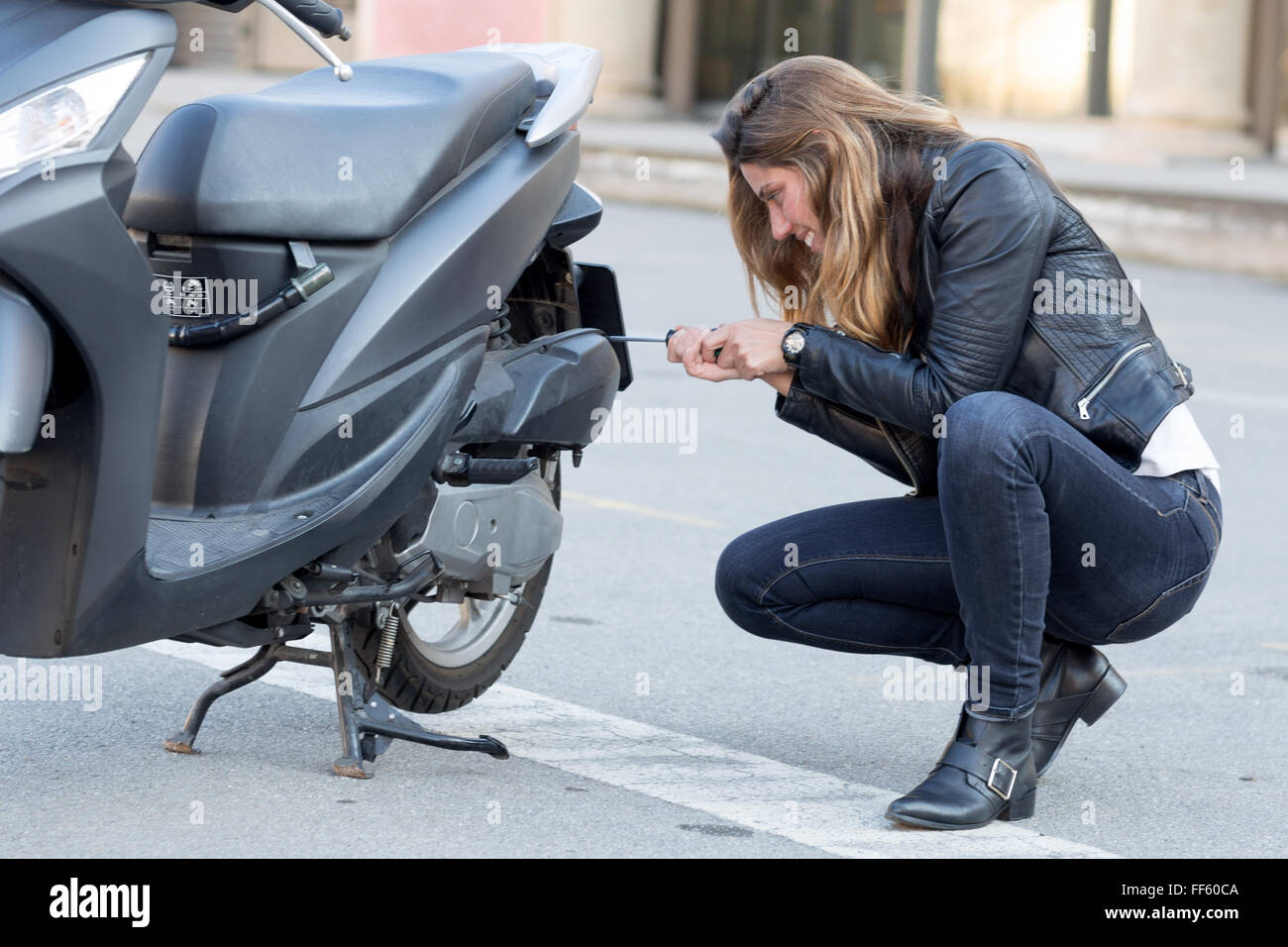 Mujer repara un scooter Fotografía de stock - Alamy