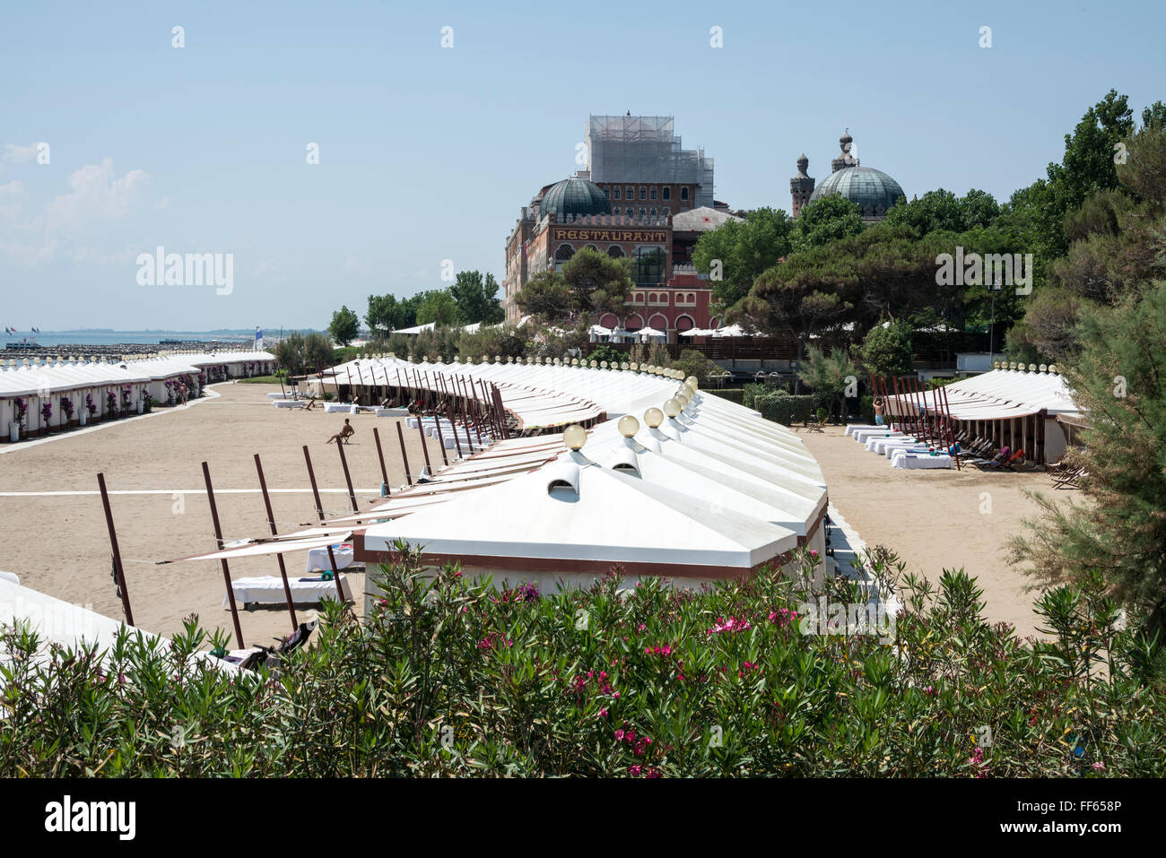 La larga playa de arena con chalets enfrente del Palazzo del Cinema del Lido di Venezia en Lungomare Guglielmo Marconi, Lido Foto de stock