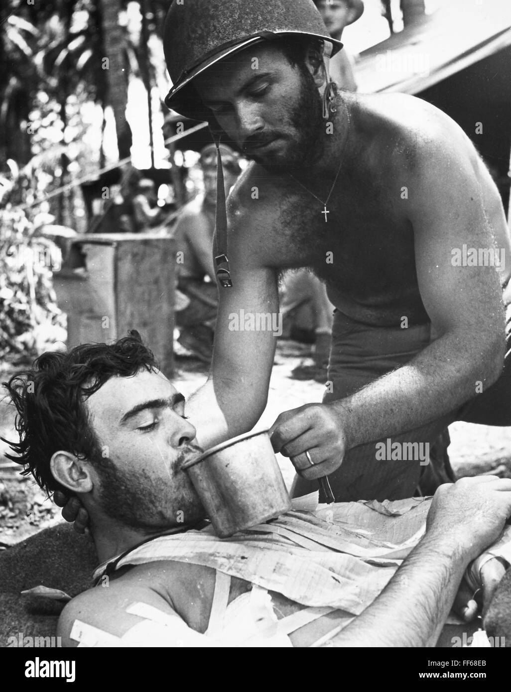 La SEGUNDA GUERRA MUNDIAL: Marina, 1944. /NA U.S. Marine herido, atendido por un oficial de la Naval, a la espera de evacuación de Bougainville, Nueva Guinea, durante la II Guerra Mundial, en 1943. Foto de stock