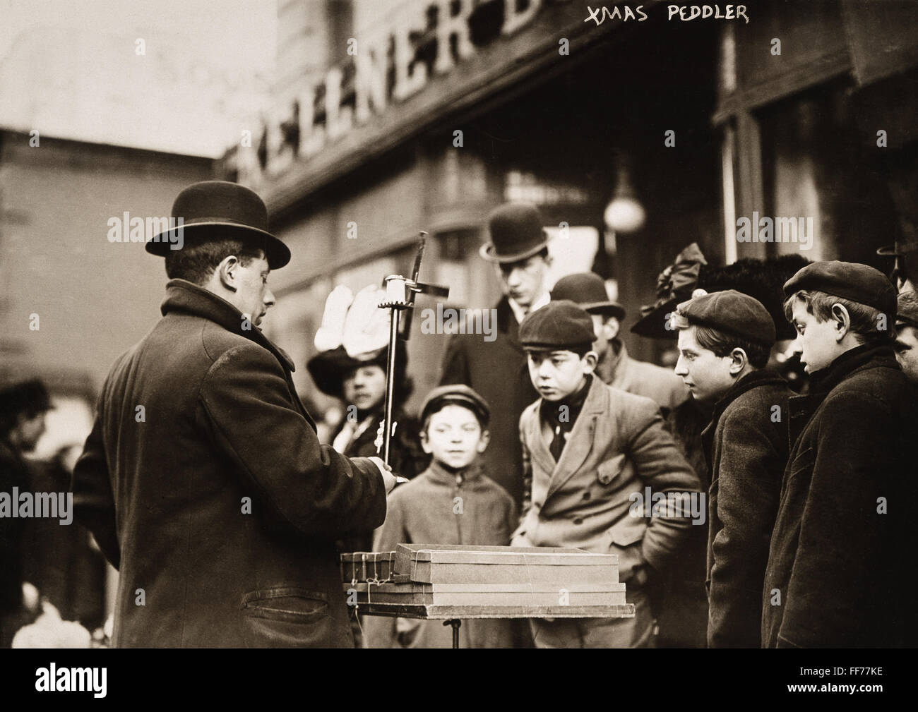 NYC STREET BUHONERO, 1910. /NA Nueva York Street buhonero demostrando whirligigs, diciembre de 1910. Foto de stock