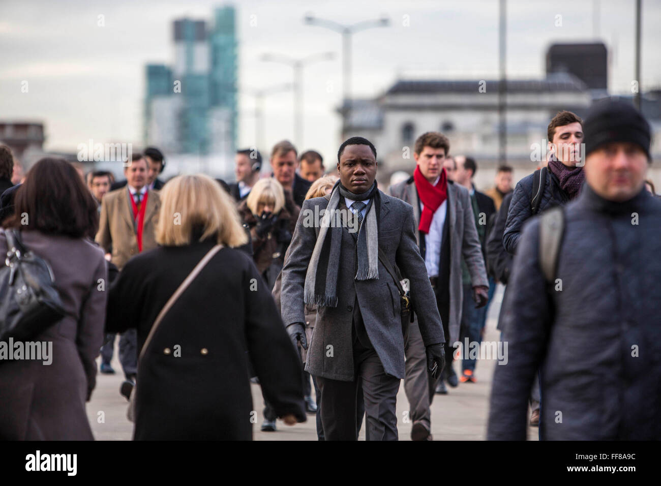 Los viajeros a pie cruzando el puente de Londres para empezar a trabajar en la ciudad de Londres, Reino Unido. Miles de viajeros llegan a la estación de London Bridge y cotidiana a pie de obra. Foto de stock