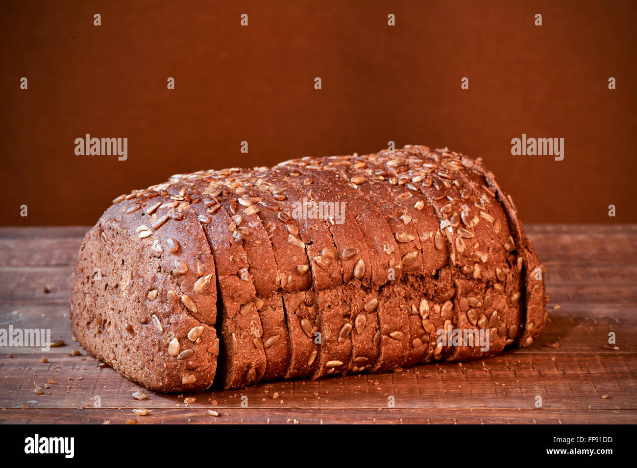 Una rebanada de pan de centeno pan cubierto con semillas de girasol en una  superficie de madera rústica Fotografía de stock - Alamy