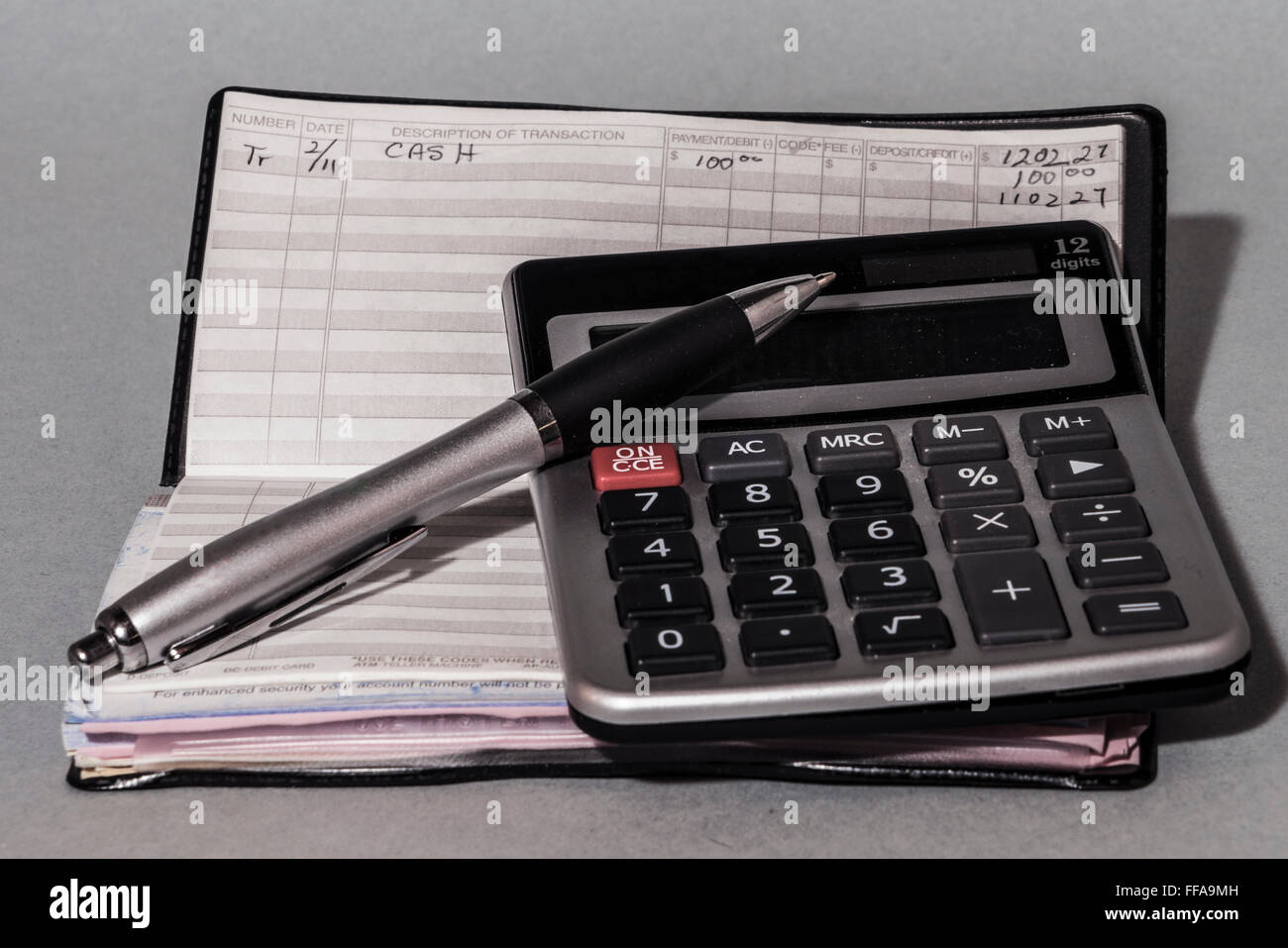 Chequera, calculadora y lápiz sugiriendo fondos y concepto de presupuesto Foto de stock
