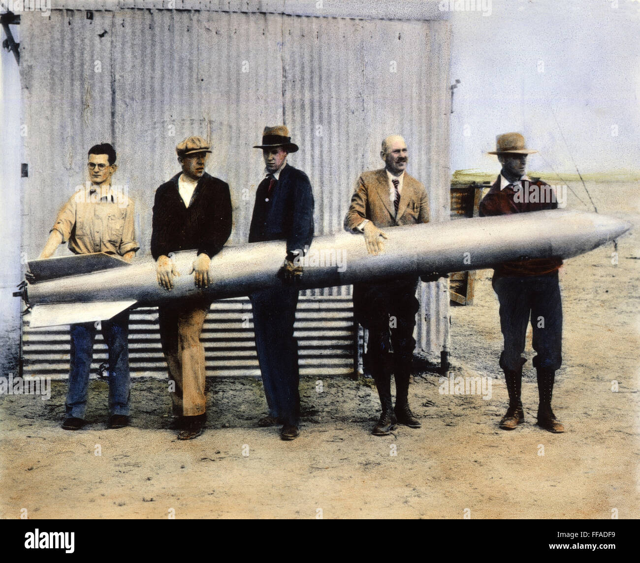 ROBERT HUTCHINGS Goddard. /N(1882-1945) el cuarto de la izquierda y los asistentes L. Mansur, A.Kisk, C. Mansur, y N.L. Jungquist sosteniendo el cohete utilizado en el vuelo del 19 de abril de 1932. Aceite sobre una fotografía de ese año. Foto de stock