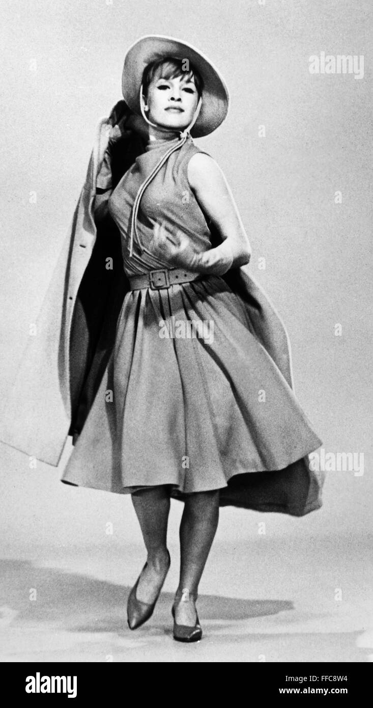 La moda femenina, 1964. /NModel que llevaba un vestido, abrigo y el sombrero por el diseñador de moda estadounidense Donald Brooks, 1964. Foto de stock