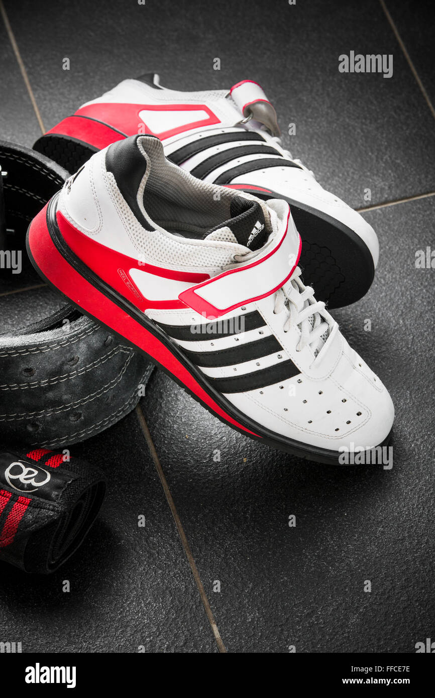 Adidas zapatos weightlifting Olímpico sobre un suelo de baldosas de color  gris con un cinturón de halterofilia y muñequeras Fotografía de stock -  Alamy