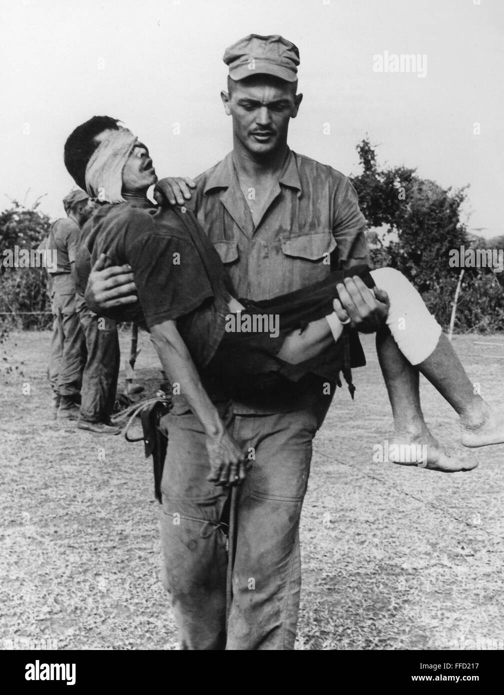 VIETNAM: sospechoso de pertenecer al Viet Cong. /NA Marina de los EE.UU. ayudante médico médico en Chu Lai, Vietnam del Sur, lleva una herida del Viet Cong sospechoso a la zona de interrogatorios, 21 de agosto de 1965. Foto de stock