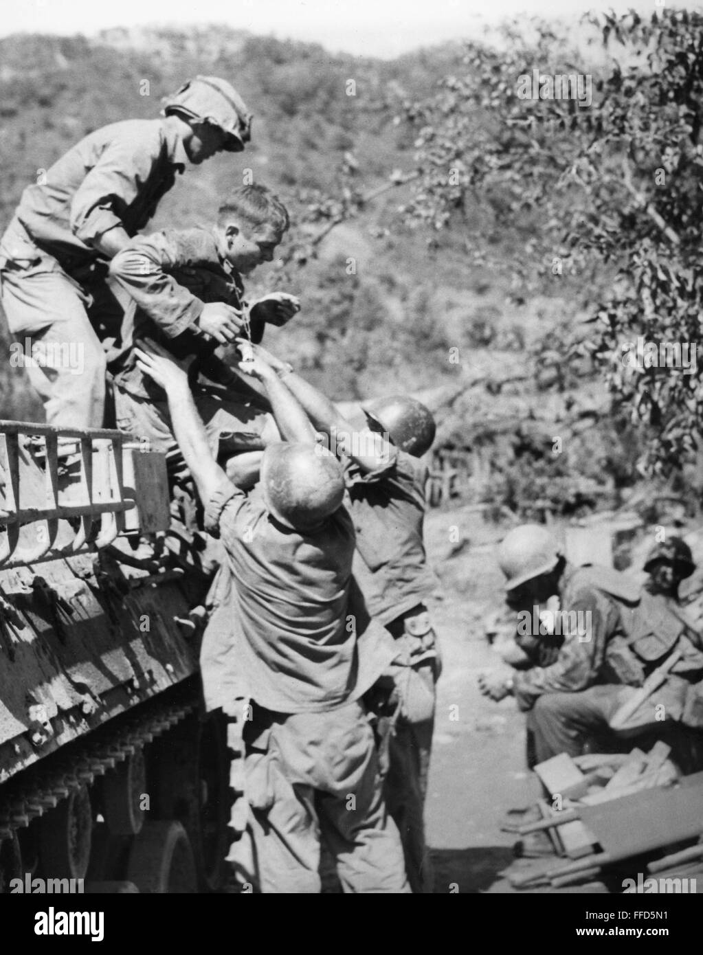Guerra de Corea: heridos, 1952. /NAn soldado americano es ayudado a un porteador personal blindado tras haber sido heridos en los combates para la colina 266, conocido como "Old Baldy", durante la Guerra de Corea, 1952. Foto de stock