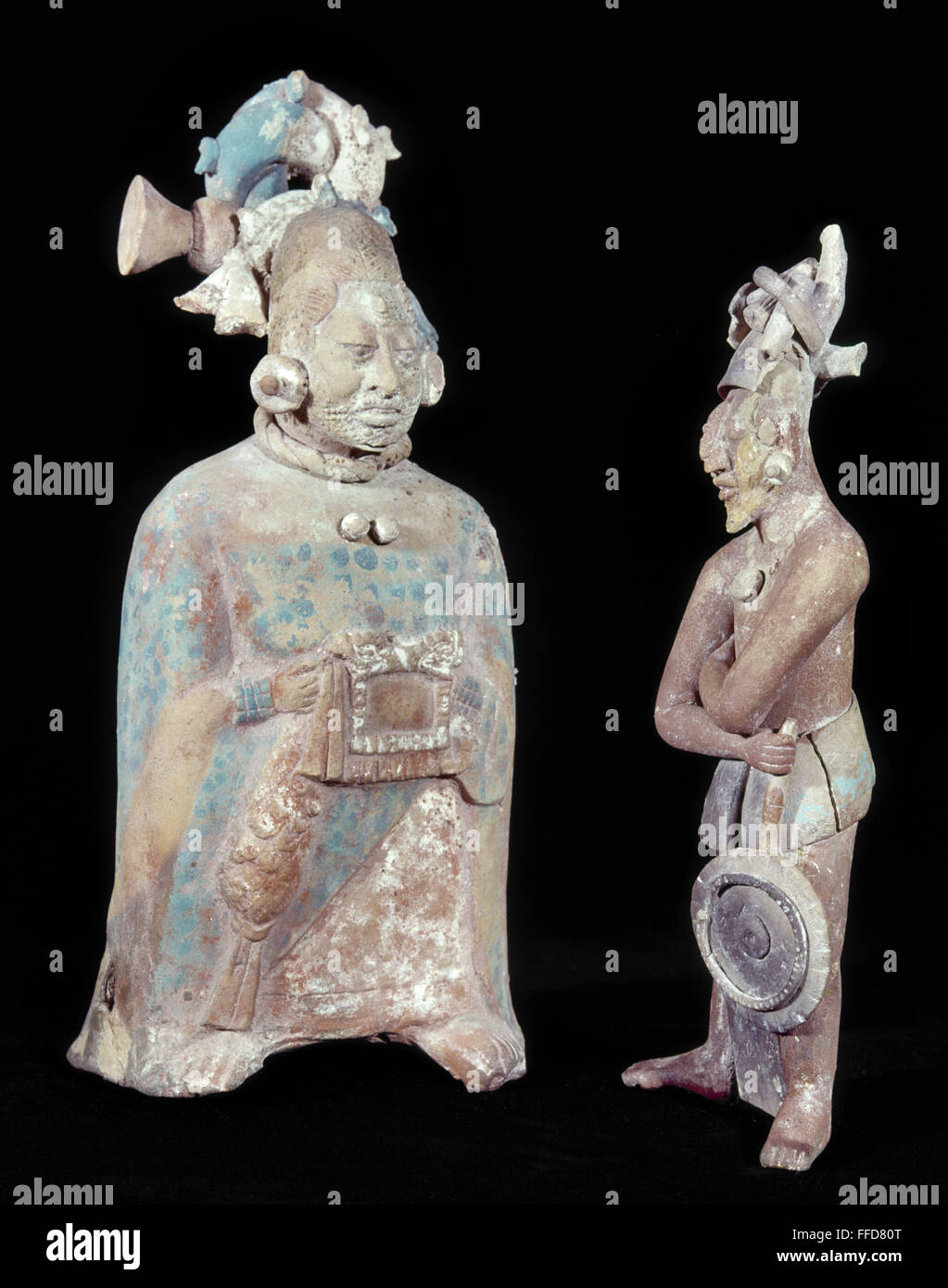 Las figuras mayas, 700-900 D.C. /nA mujer Maya ricamente vestida con cicatrices en el rostro, ya sea para el sacrificio o la vanidad. El hombre de la derecha está llevando un ventilador. De Jaina, Campeche, México, 700-900 D.C. Alturas: 21,2 cm y 19 cm respectivamente. Foto de stock