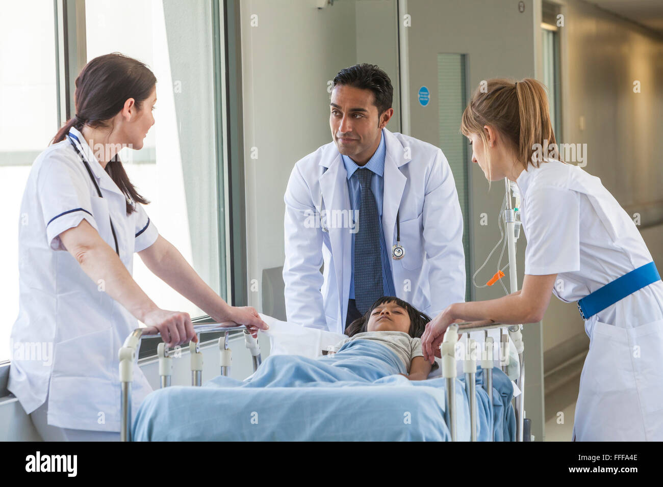 Niño enfermo paciente en camilla, cama o camilla en un corredor de hospital  con médico y enfermeras Fotografía de stock - Alamy