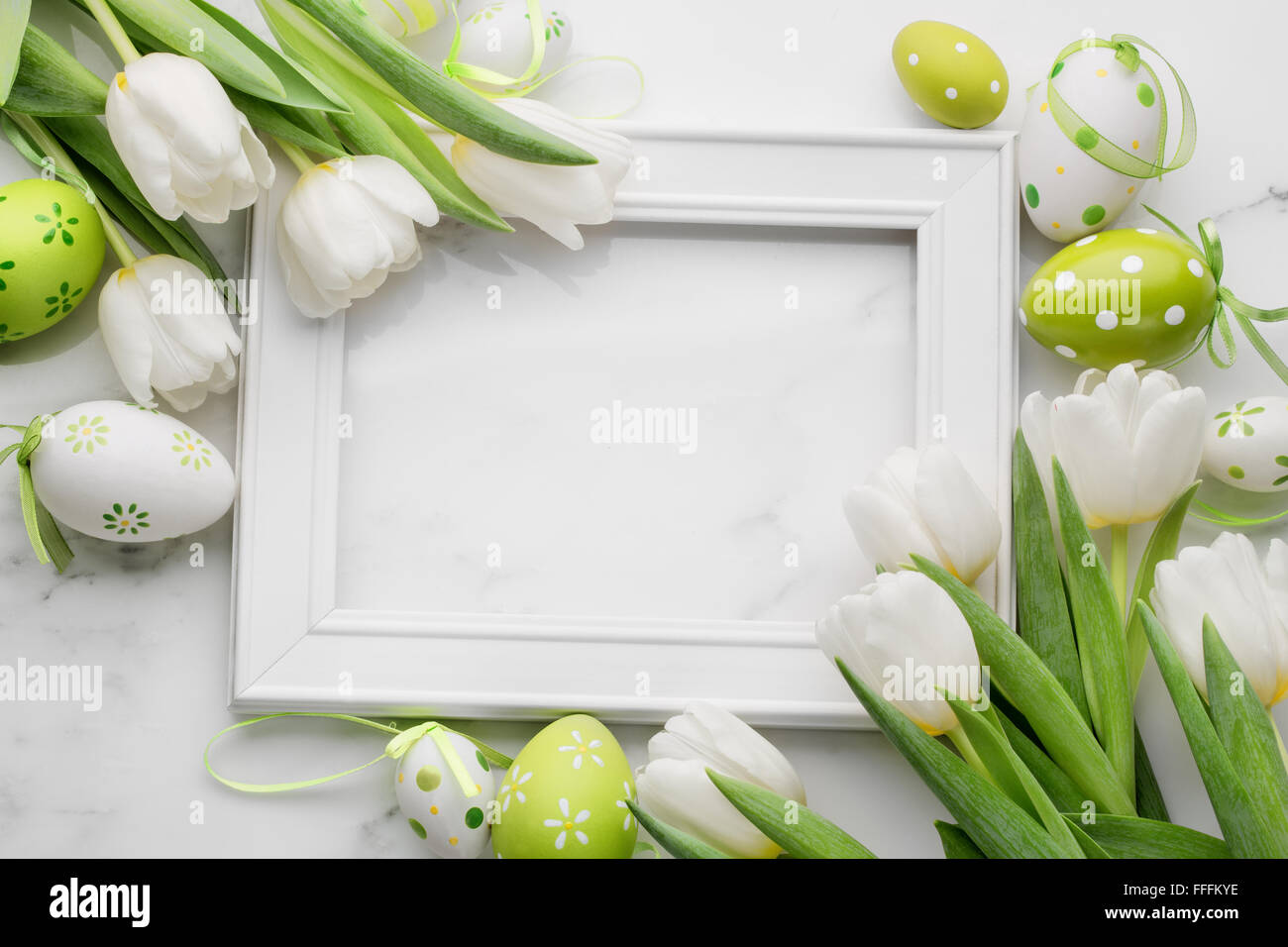 Tulip,huevos de pascua y marco de imagen en blanco sobre fondo de mármol blanco Foto de stock