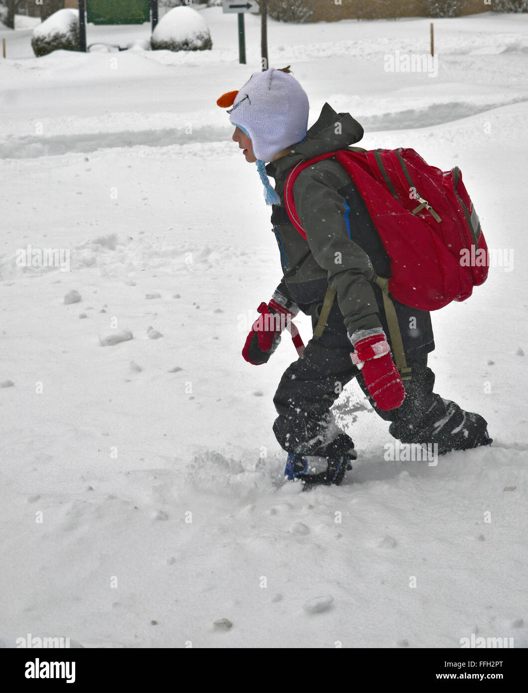 Niño caminando a través de la profundidad de la nieve. Foto de stock