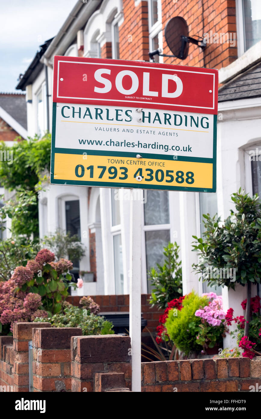 La comercialización de letreros de venta de agente inmobiliario local Charles Harding fuera de las casas en una calle en Swindon, Wiltshire, UK Foto de stock