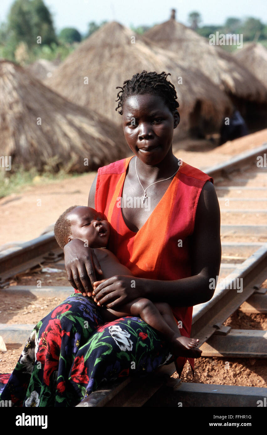 Madre con su bebé sentado en las vías del ferrocarril, en un campamento de refugiados en Lira, en el norte de Uganda. Estos refugiados que huían de los rebeldes del LRA atacando el norte de Uganda. Foto de stock