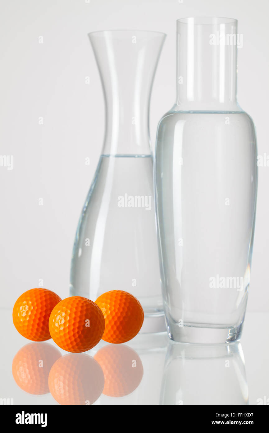 Dos jarrones con agua limpia y pelotas de golf sobre una mesa de vidrio  Fotografía de stock - Alamy