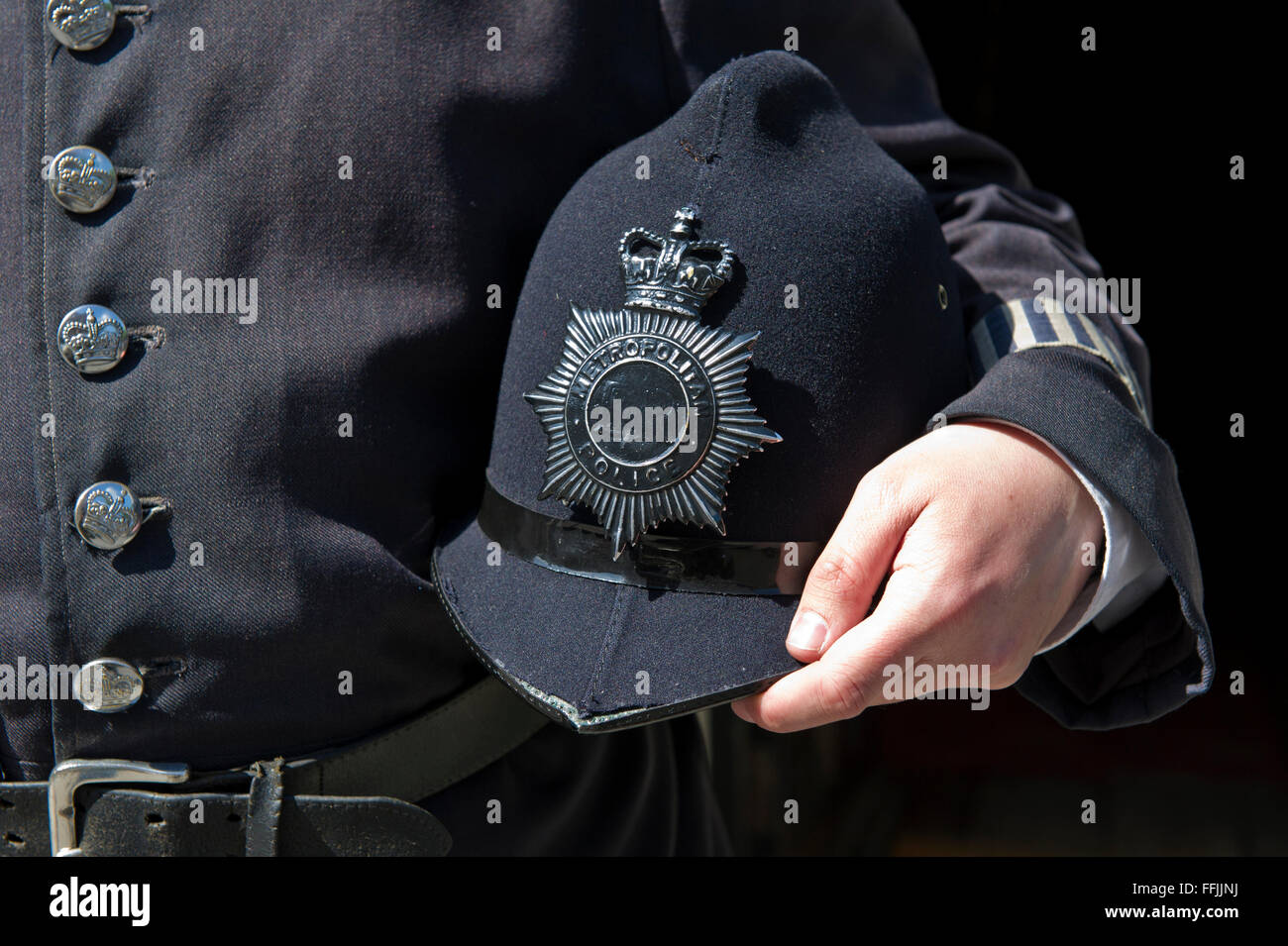 Un hombre sostiene un viejo casco de policía fuera del famoso museo de Sherlock Holmes en Baker Street, Londres, Reino Unido. Foto de stock