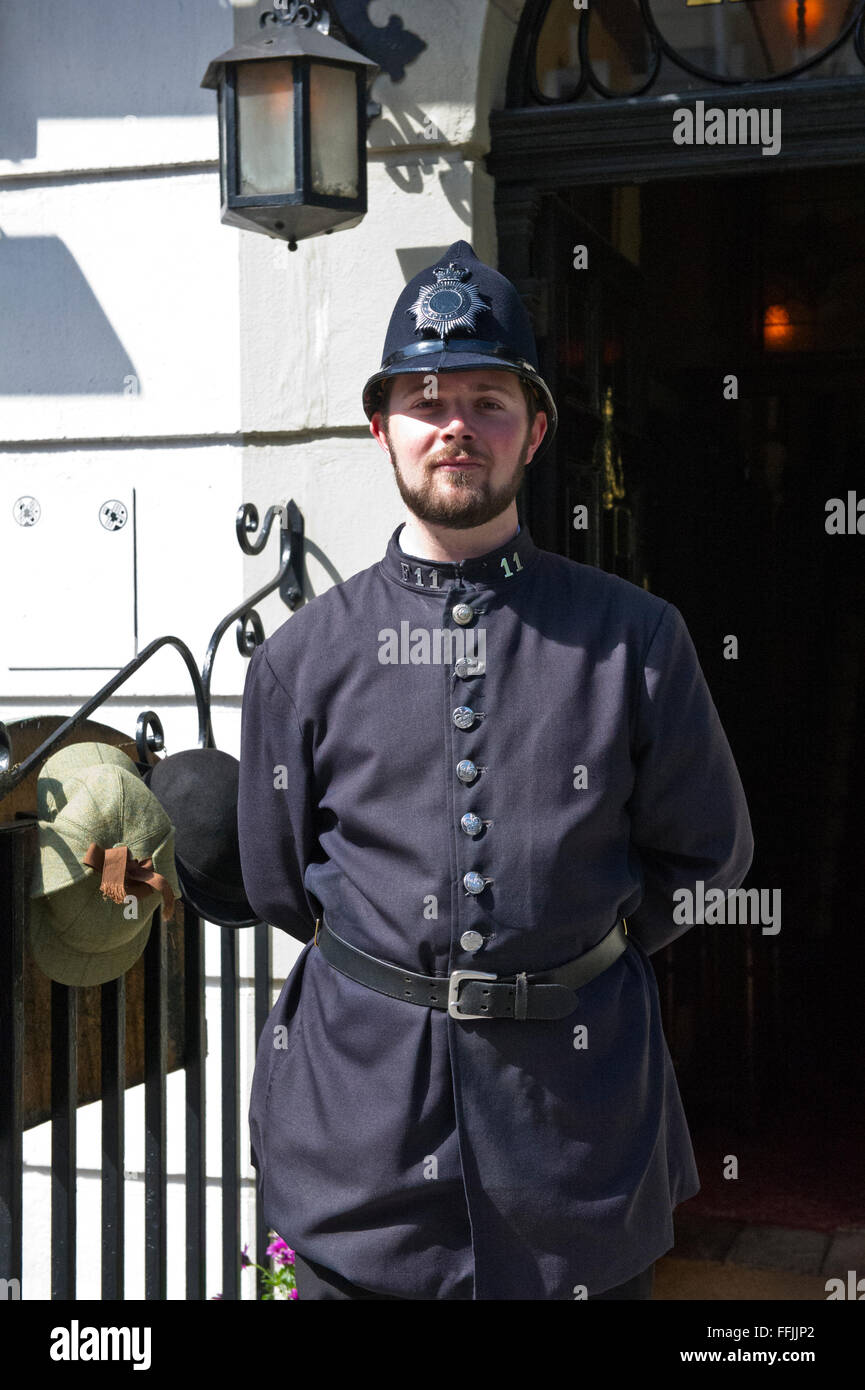Un hombre con traje (antiguo uniforme de policía) fuera del famoso museo de Sherlock Holmes en Baker Street, Londres, Reino Unido. Foto de stock