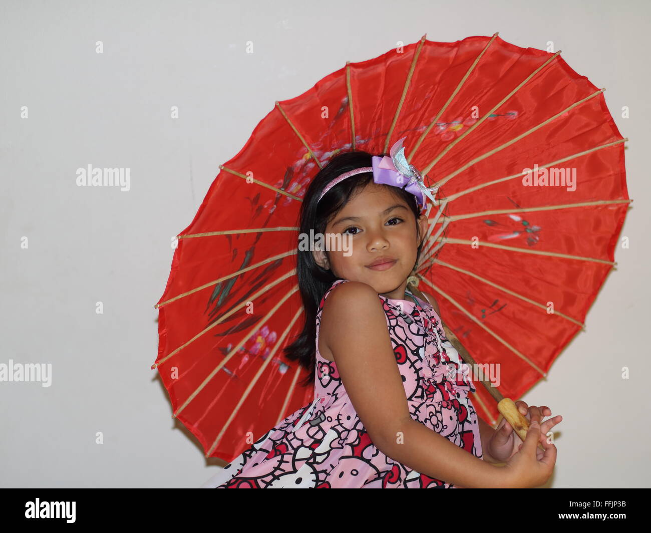 Una niña sosteniendo un paraguas. Foto de stock