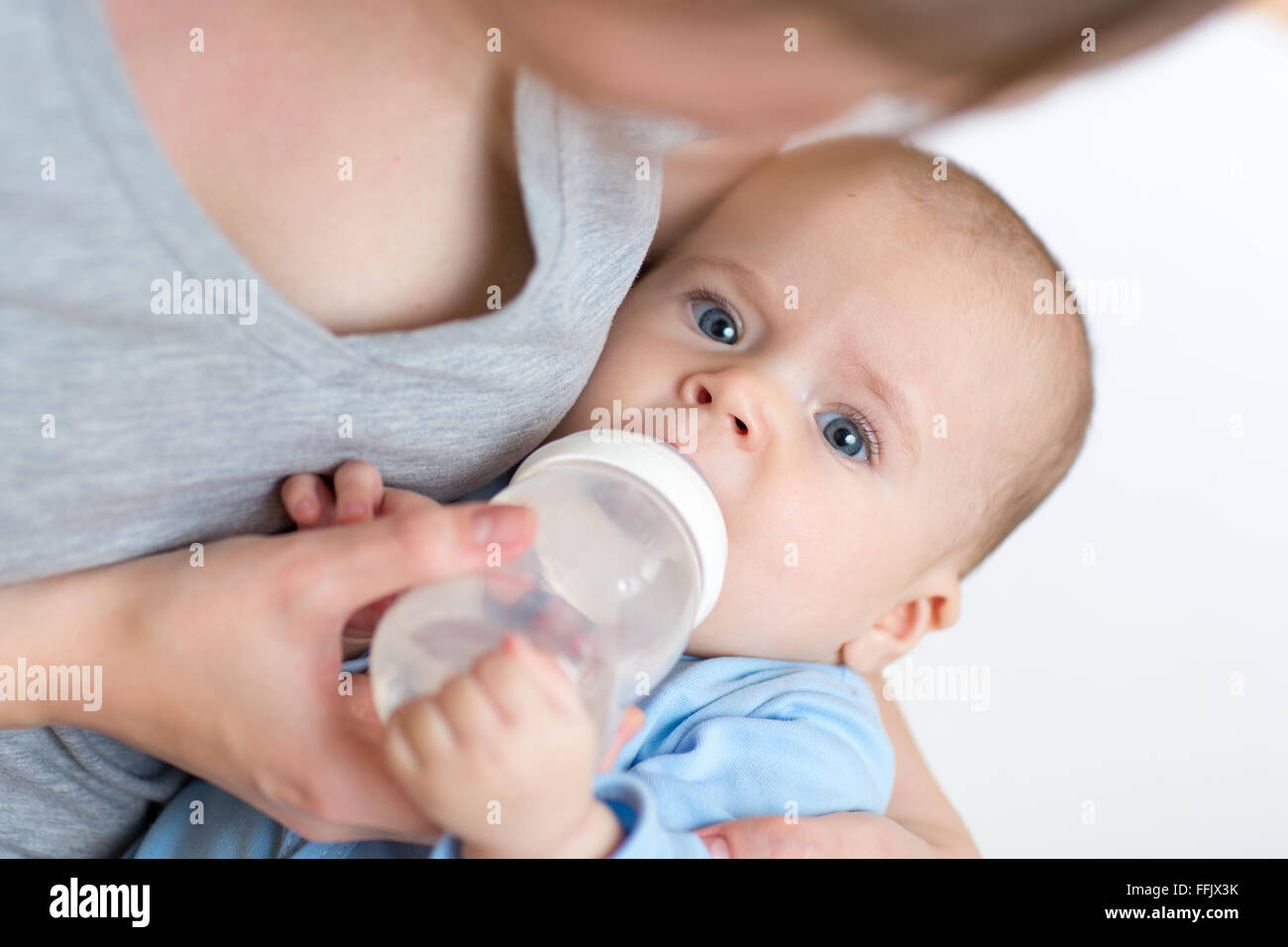Madre alimentando a su bebé lactante de botella Foto de stock