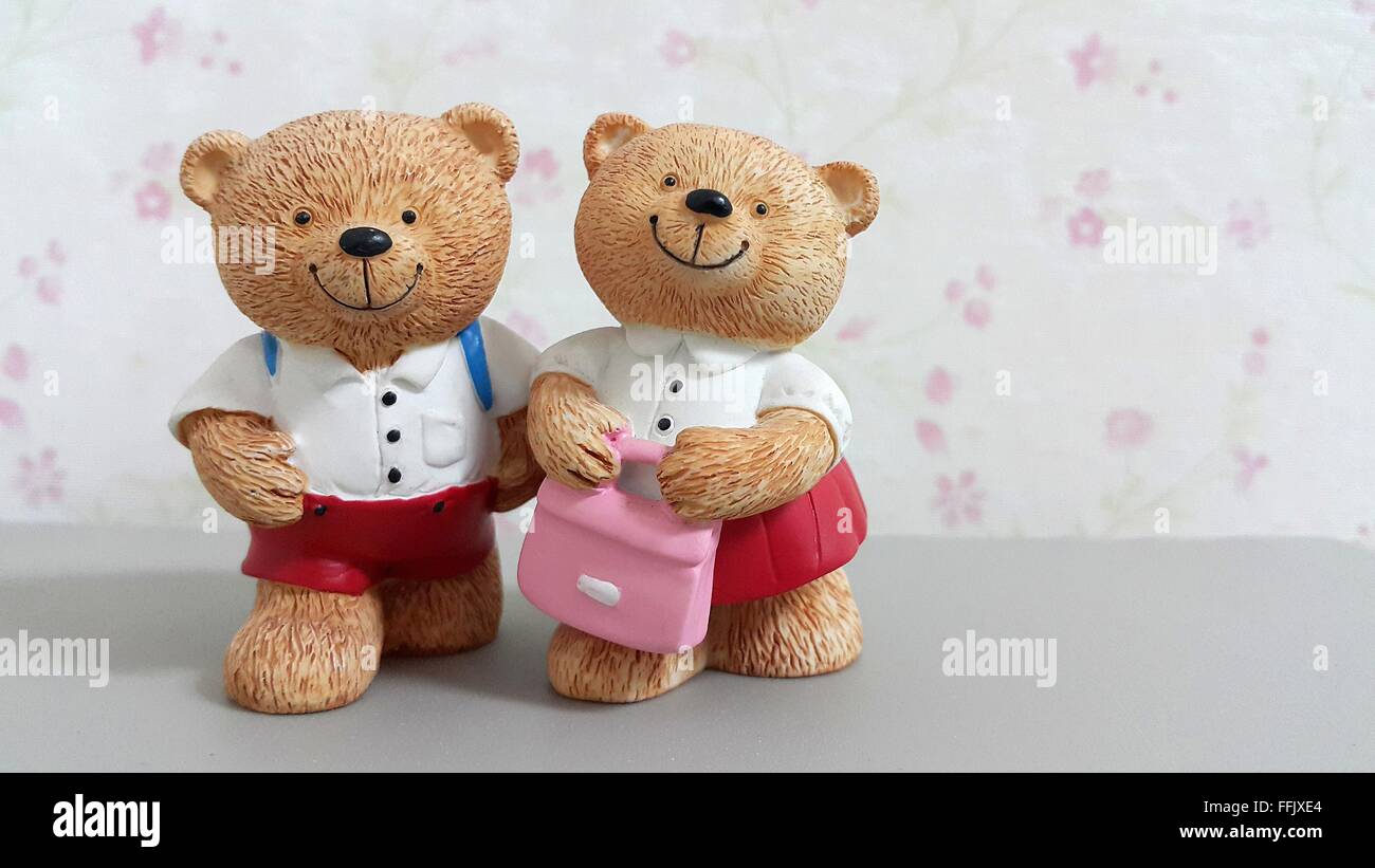 Par de tener muñecos de cerámica uniforme escolar ir a la escuela en flor  rosa borrosa fondo de pantalla Fotografía de stock - Alamy