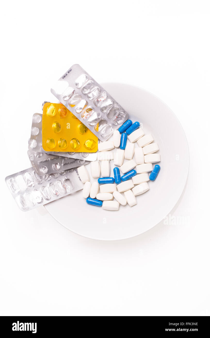 Placa con blanco y azul píldoras médicas para el tratamiento de enfermedades Foto de stock