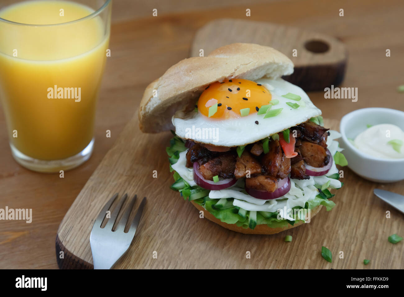 Hamburguesa casera con huevo frito y picante con papas fritas en tablón de madera Fotografía de Hamburguesa casera con huevo frito y picante con papas fritas en tablón de madera Fotografía de