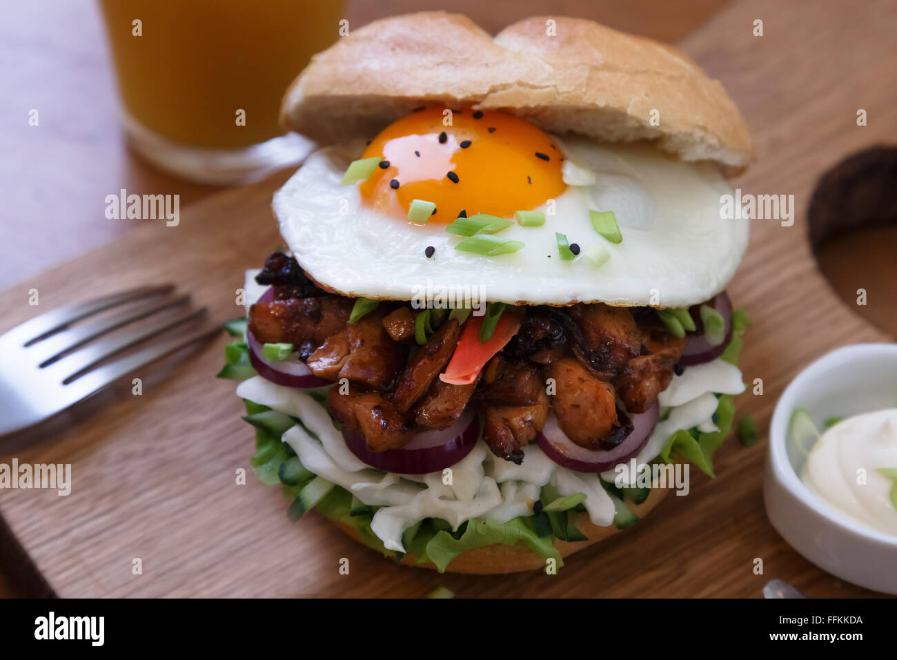 Hamburguesa casera con huevo frito y picante con papas fritas en tablón de madera Fotografía de Hamburguesa casera con huevo frito y picante con papas fritas en tablón de madera Fotografía de