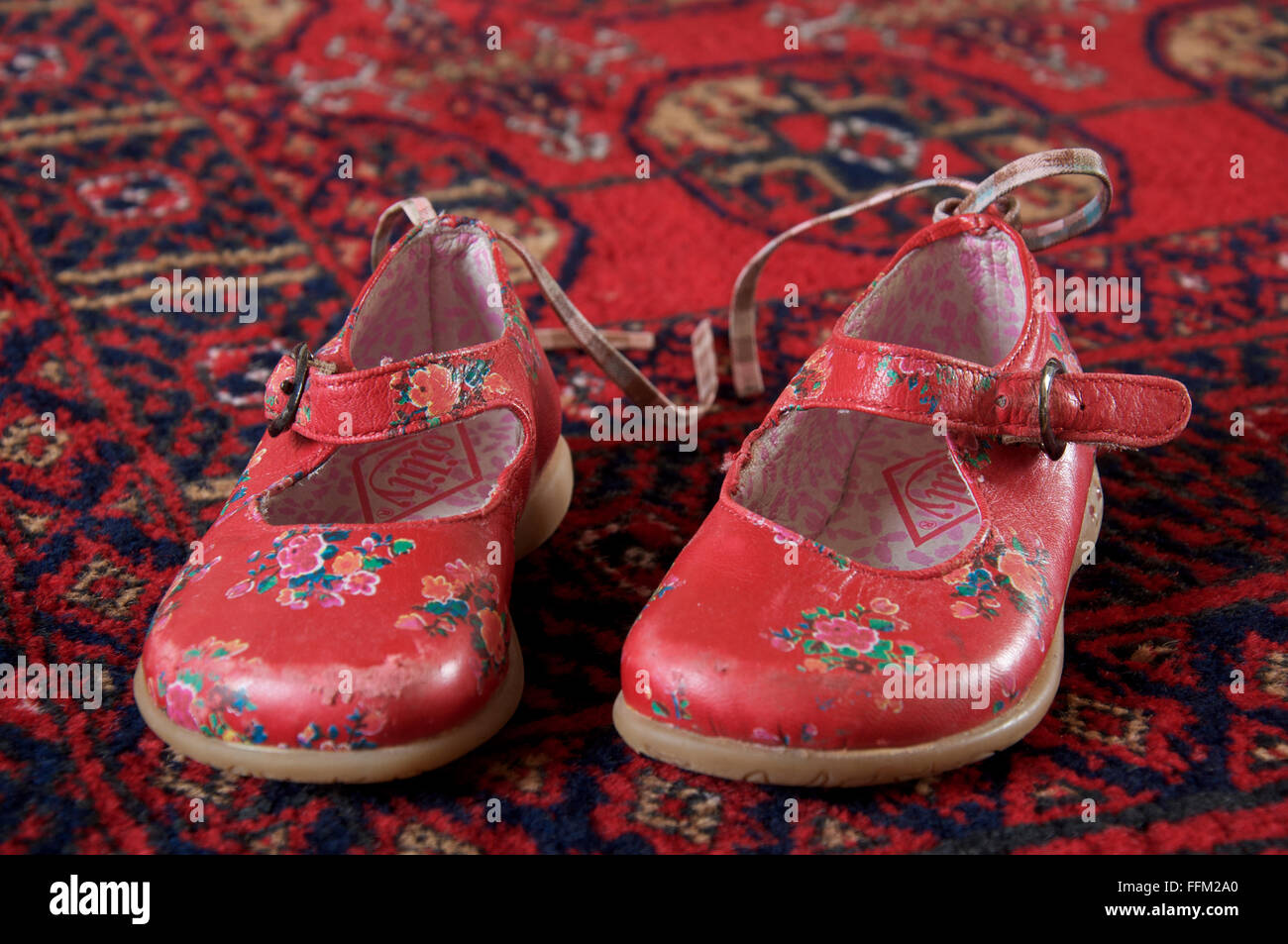canal Vagabundo Hobart Un par bien gastado de niña de brillantes zapatos rojos colocados sobre una  alfombra Fotografía de stock - Alamy